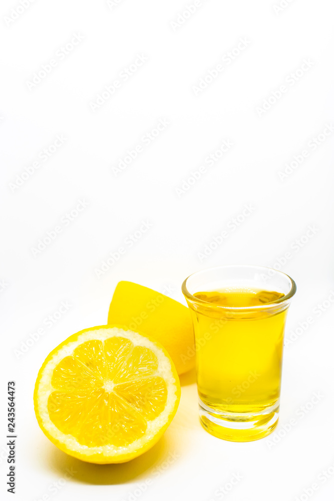 A Mexican tequila shot with lemon on a white isolated background A Mexican tequila shot with lemon on a white isolated background