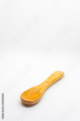 Small light wooden spoon on a white isolated background with blank space for text