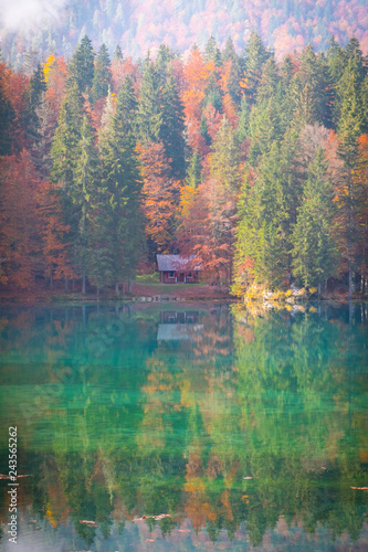 Lake Laghi di Fusine in autumn with a small hut