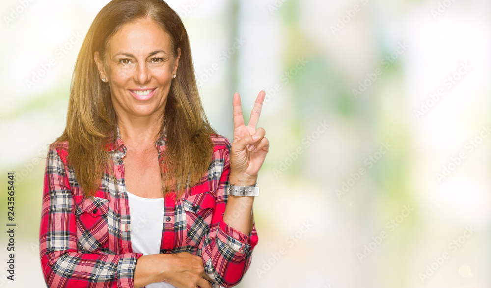Middle age adult woman wearing casual shirt over isolated background smiling with happy face winking at the camera doing victory sign. Number two. Middle age adult woman wearing casual shirt over isolated background smiling with happy face winking at the camera doing victory sign. Number two.