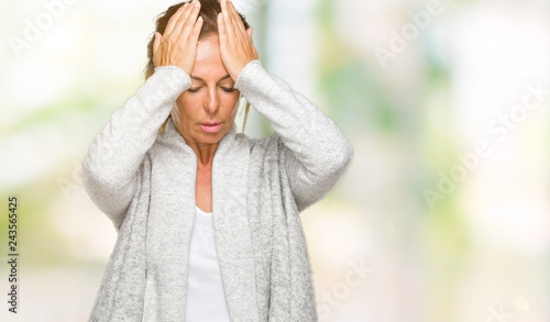 Beautiful middle age adult woman wearing winter sweater over isolated background suffering from headache desperate and stressed because pain and migraine. Hands on head.