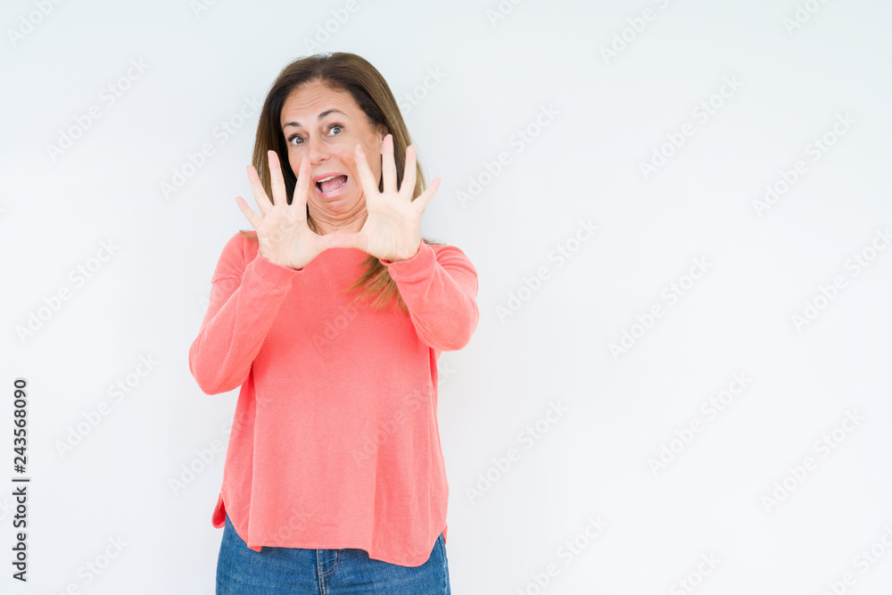 Beautiful middle age woman over isolated background afraid and terrified with fear expression stop gesture with hands, shouting in shock. Panic concept. Beautiful middle age woman over isolated background afraid and terrified with fear expression stop gesture with hands, shouting in shock. Panic concept.