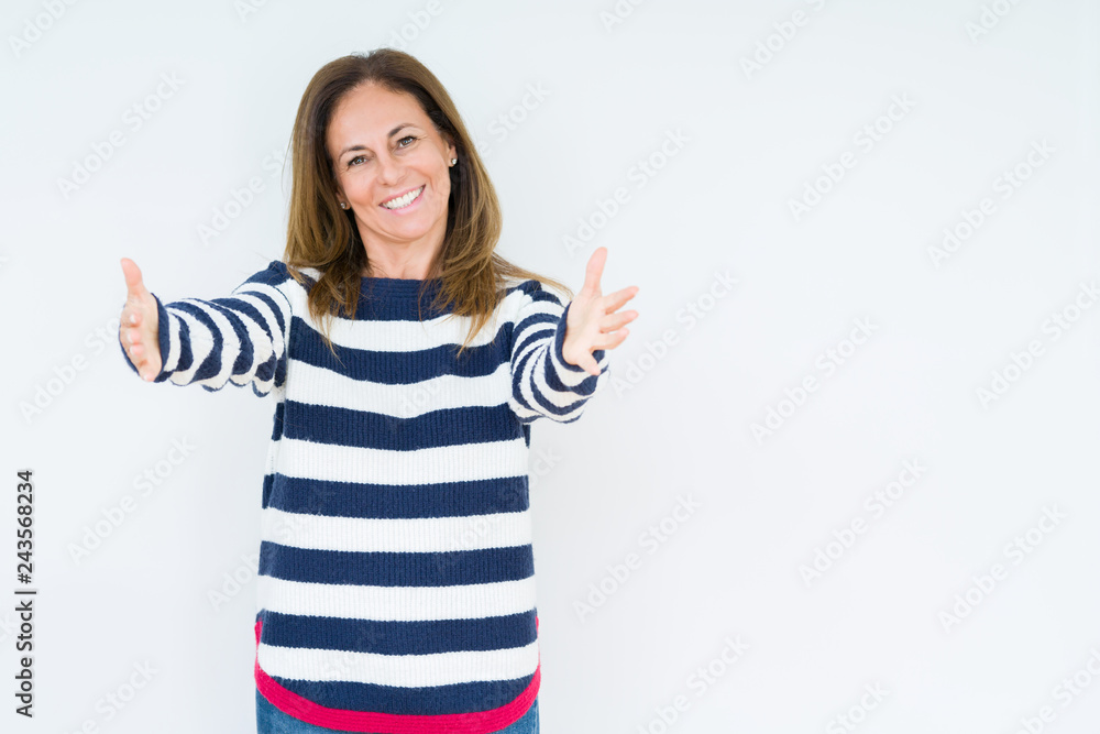 Beautiful middle age woman wearing navy sweater over isolated background looking at the camera smiling with open arms for hug. Cheerful expression embracing happiness. Beautiful middle age woman wearing navy sweater over isolated background looking at the camera smiling with open arms for hug. Cheerful expression embracing happiness.