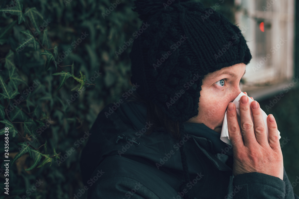 Woman blowing her nose into paper handkerchief Woman blowing her nose into paper handkerchief