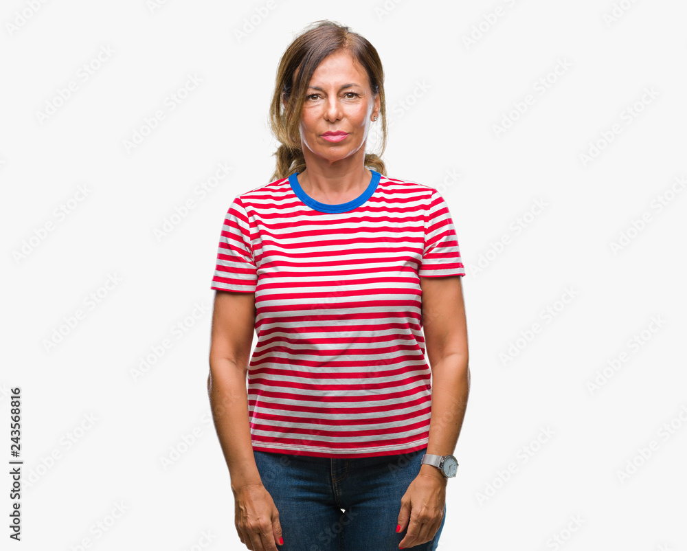 Fototapeta premium Middle age senior hispanic woman over isolated background with serious expression on face. Simple and natural looking at the camera.