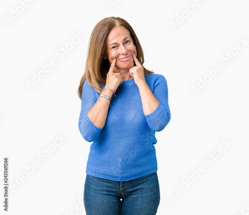 Middle age beautiful woman wearing winter sweater over isolated background Smiling with open mouth  fingers pointing and forcing