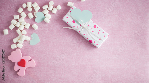 box, turquoise hearts, marshmallow, pink bear lie on a pink background (horizontally)