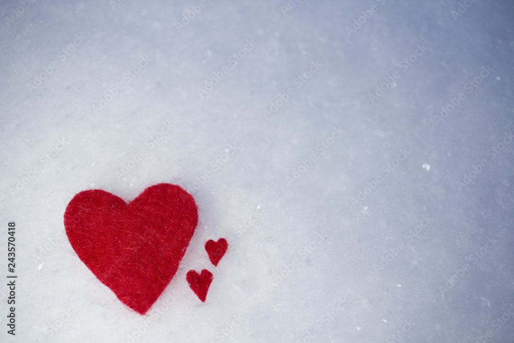the red hearts are big and the little ones are lying on the snow