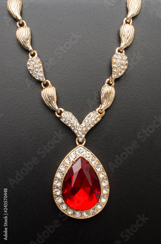 golden pendant with ruby and diamonds isolated on black macro