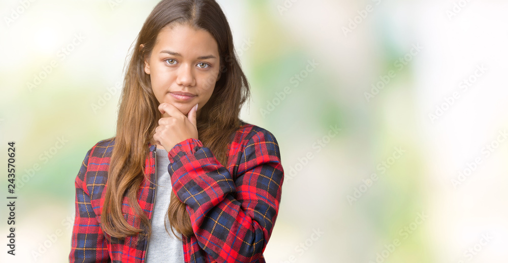 Young beautiful brunette woman wearing a jacket over isolated background looking confident at the camera with smile with crossed arms and hand raised on chin. Thinking positive. Young beautiful brunette woman wearing a jacket over isolated background looking confident at the camera with smile with crossed arms and hand raised on chin. Thinking positive.