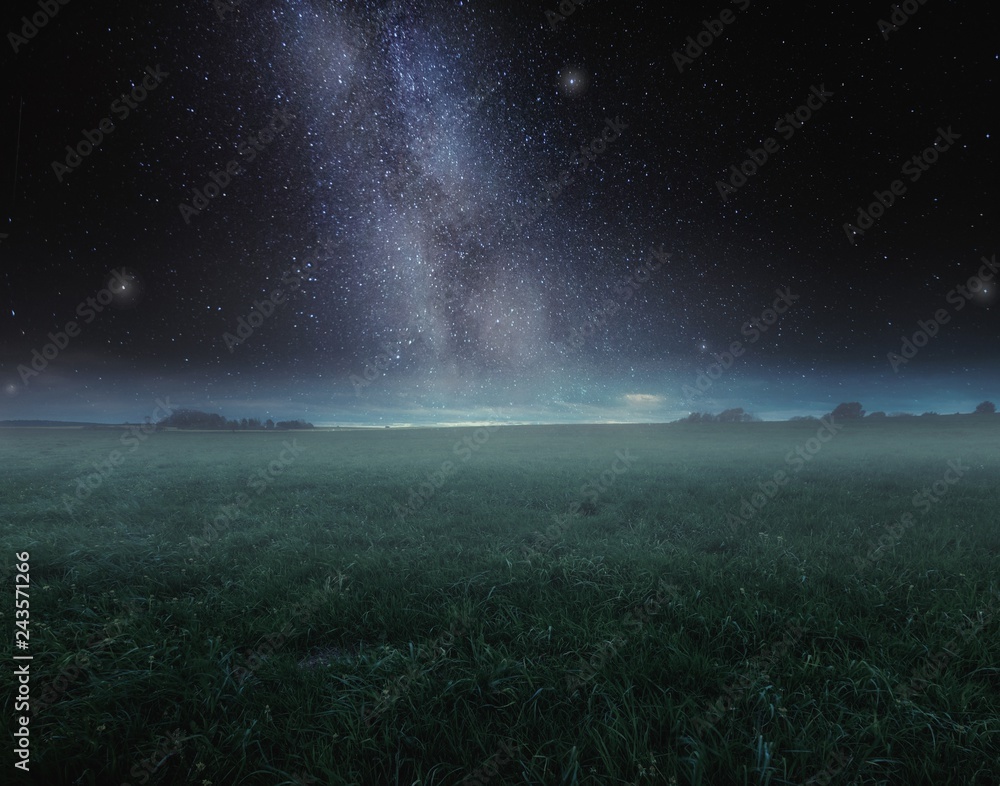 Surreal night landscape with field under stars.