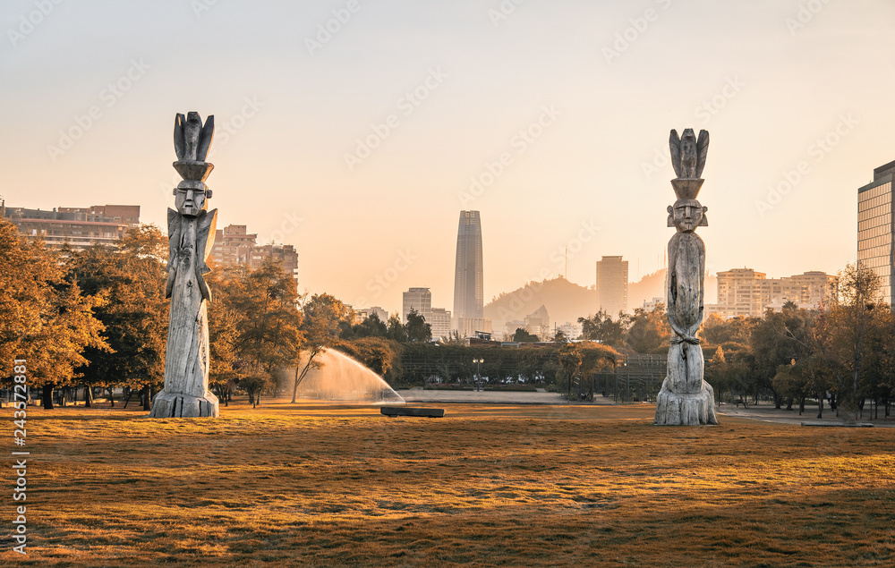 Santiago skyline at Araucano Park and chemamules traditional mapuche sculptures - Santiago, Chile