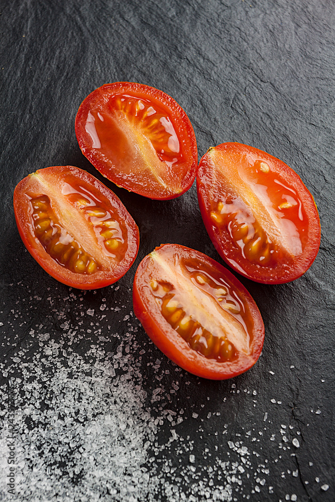 TROZOS DE TOMATE CON SAL MARINA SOBRE FONDO OSCURO TROZOS DE TOMATE CON SAL MARINA SOBRE FONDO OSCURO