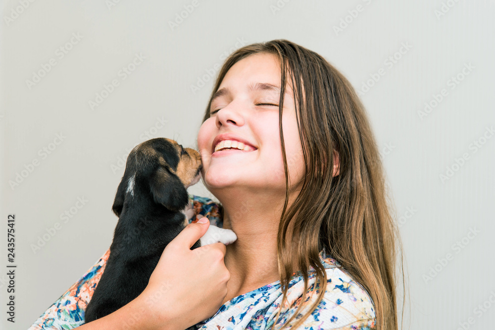Obraz premium Cute teenage girl hugging a beagle puppy. Cute young woman with a puppy dog.