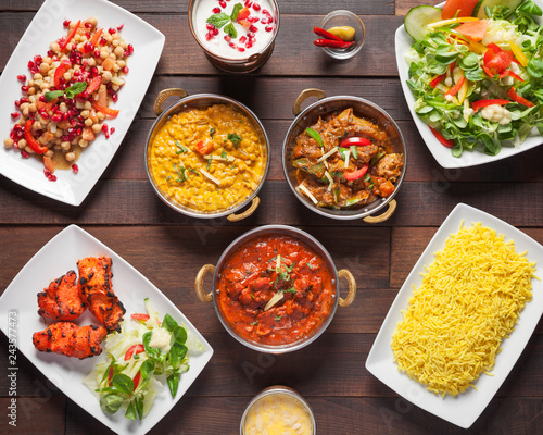 Indian food, top down view - Delicious mixed oriental dishes, beautifully arranged and surved on a wooden table	