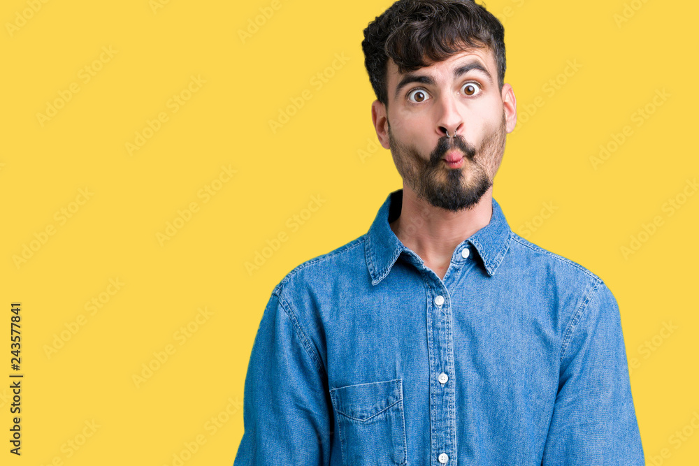 Obraz premium Young handsome man over isolated background making fish face with lips, crazy and comical gesture. Funny expression.
