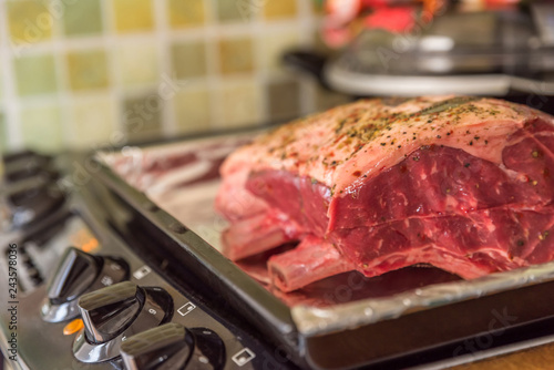 closeup view raw beef cross rib chunk on oven tray with foil on electric cooker photo