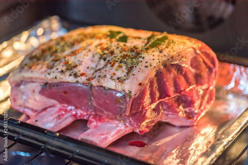 closeup view raw beef cross rib chunk on oven tray with foil inside oven photo