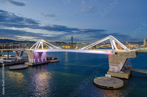  Port Vell with its bridge Porta d'Europa and the aerial tramway tower Torre Jaume I in Barcelona at night