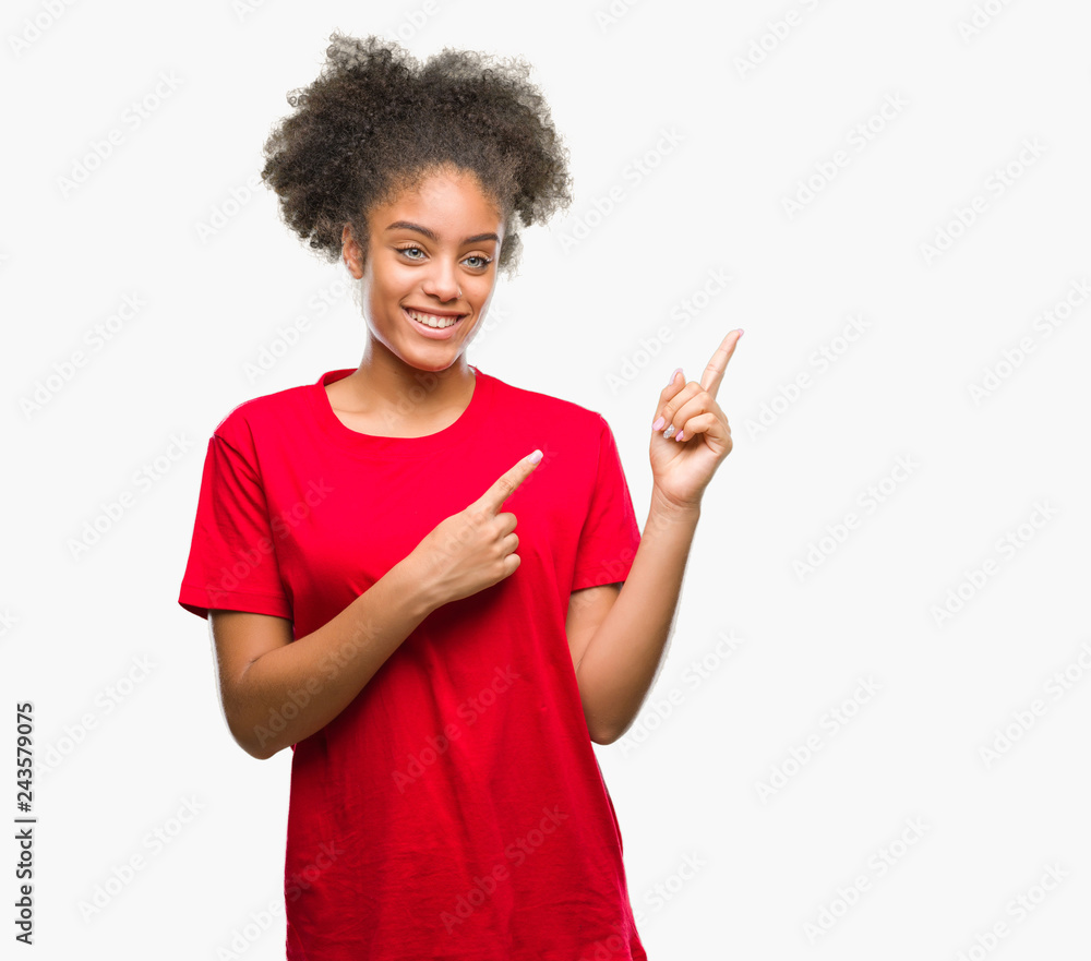 Young afro american woman over isolated background smiling and looking at the camera pointing with two hands and fingers to the side. Young afro american woman over isolated background smiling and looking at the camera pointing with two hands and fingers to the side.