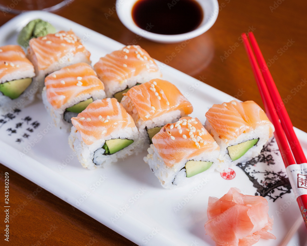 Top down view of fresh avocado California rolls, beautifully arranged on a white plate Top down view of fresh avocado California rolls, beautifully arranged on a white plate