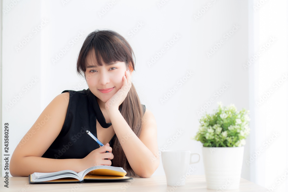 Beautiful young asian woman smiling sitting study and learning writing notebook and diary in the living room at home, girl homework, business woman working on table, education concept. Beautiful young asian woman smiling sitting study and learning writing notebook and diary in the living room at home, girl homework, business woman working on table, education concept.