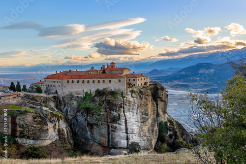 Agios Stephanos or Saint Stephen monastery located on the huge rock with mountains and town landscape in the background, Meteors, Trikala, Thessaly, Greece photo