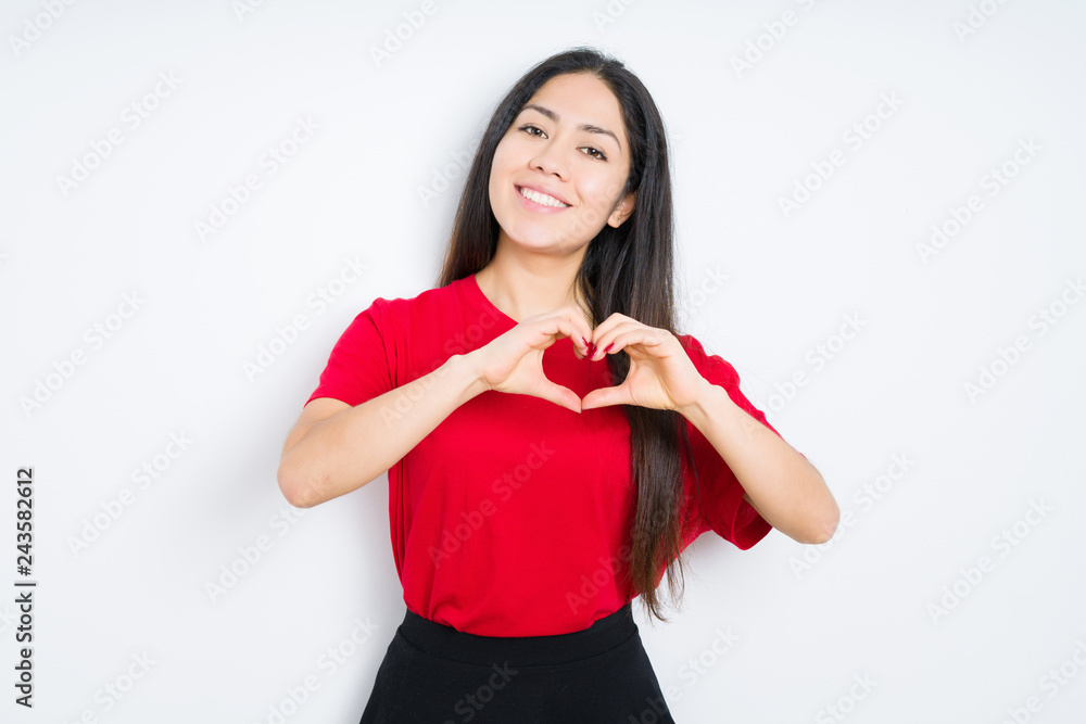 Beautiful brunette woman wearing red t-shirt over isolated background smiling in love showing heart symbol and shape with hands. Romantic concept. Beautiful brunette woman wearing red t-shirt over isolated background smiling in love showing heart symbol and shape with hands. Romantic concept.