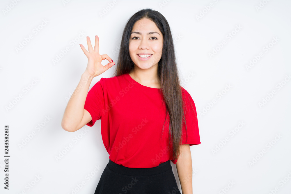 Beautiful brunette woman wearing red t-shirt over isolated background smiling positive doing ok sign with hand and fingers. Successful expression. Beautiful brunette woman wearing red t-shirt over isolated background smiling positive doing ok sign with hand and fingers. Successful expression.