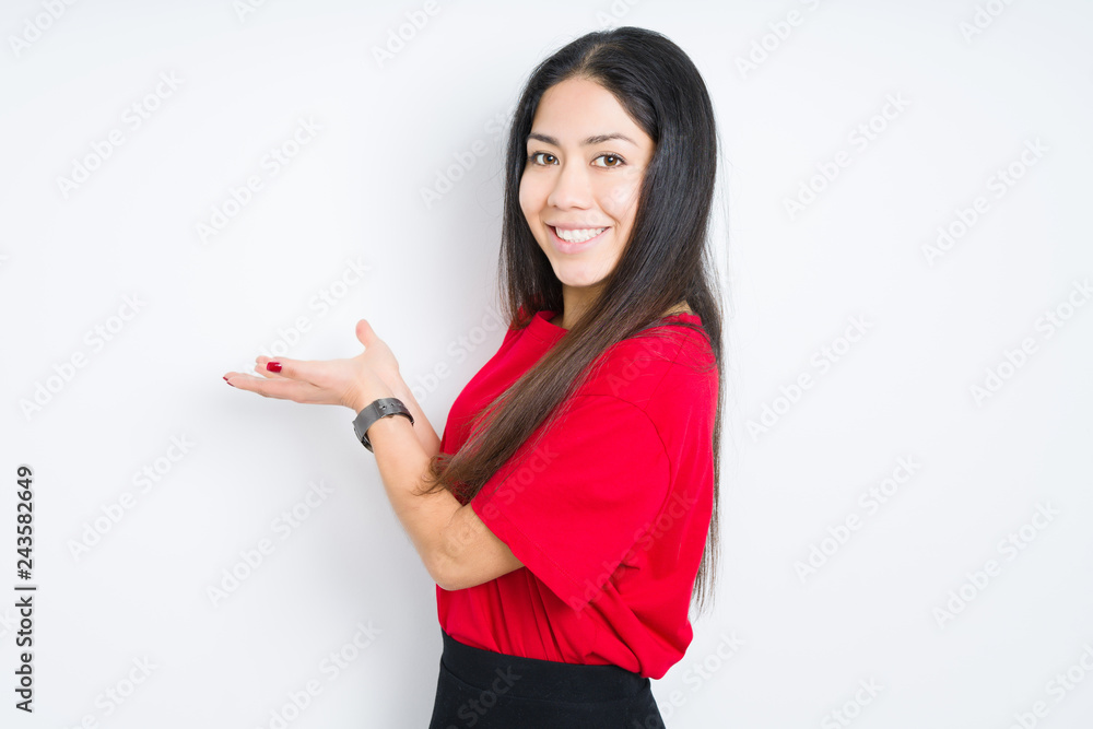 Beautiful brunette woman wearing red t-shirt over isolated background Pointing to the side with hand and open palm, presenting ad smiling happy and confident Beautiful brunette woman wearing red t-shirt over isolated background Pointing to the side with hand and open palm, presenting ad smiling happy and confident