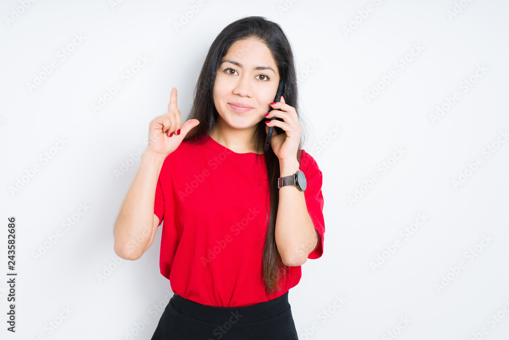 Young brunette woman talking on smartphone over isolated background surprised with an idea or question pointing finger with happy face, number one Young brunette woman talking on smartphone over isolated background surprised with an idea or question pointing finger with happy face, number one