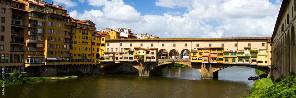 Obraz premium The Shopping Bridge - Colorful Ponte Vecchio - a bridge hosting many jewelry shops - crosses the River Arno. Florence, Italy