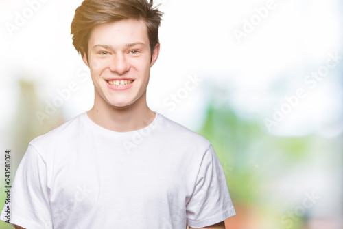 Young handsome man wearing casual white t-shirt over isolated background with a happy and cool smile on face. Lucky person.