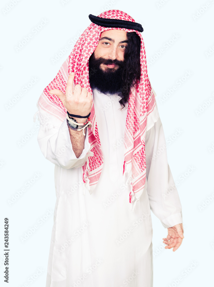 Arabian business man with long hair wearing traditional keffiyeh scarf Beckoning come here gesture with hand inviting happy and smiling Arabian business man with long hair wearing traditional keffiyeh scarf Beckoning come here gesture with hand inviting happy and smiling