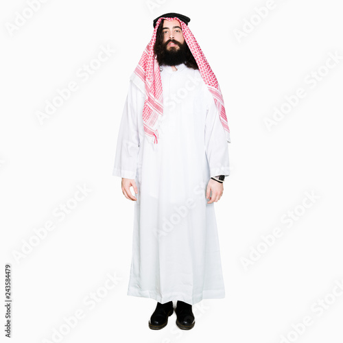 Arabian business man with long hair wearing traditional keffiyeh scarf Relaxed with serious expression on face. Simple and natural looking at the camera.