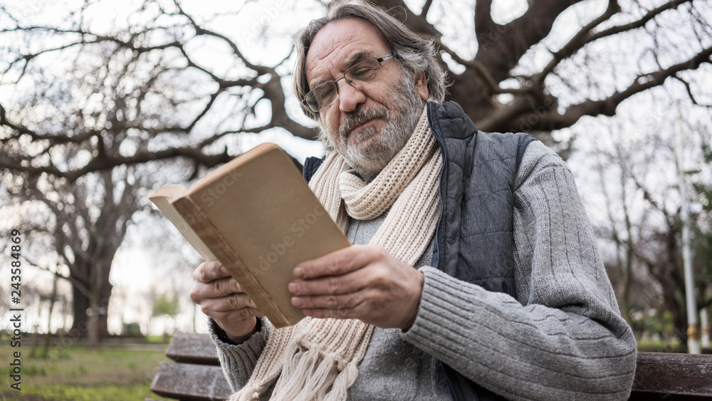 Old man reading book in the park Old man reading book in the park
