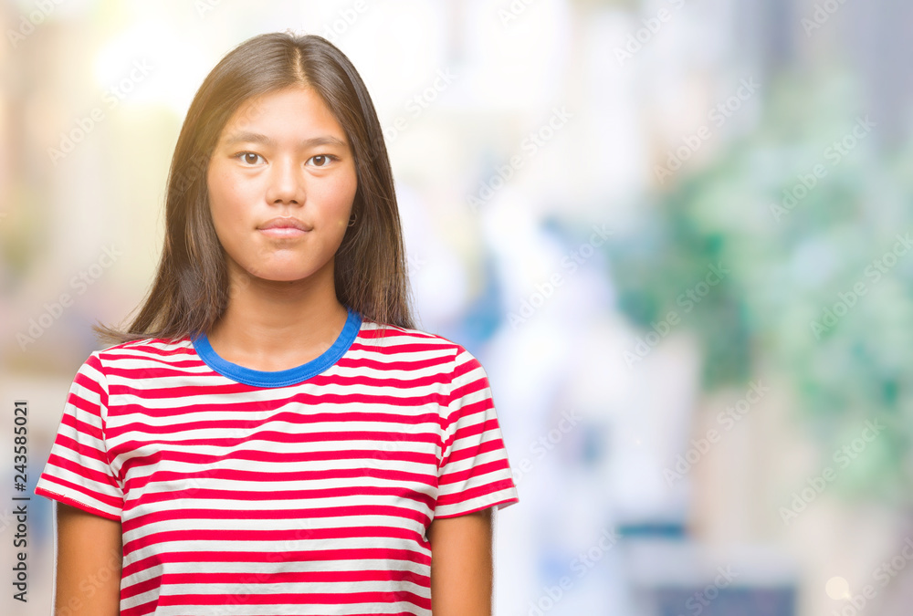 Young asian woman over isolated background with serious expression on face. Simple and natural looking at the camera. Young asian woman over isolated background with serious expression on face. Simple and natural looking at the camera.