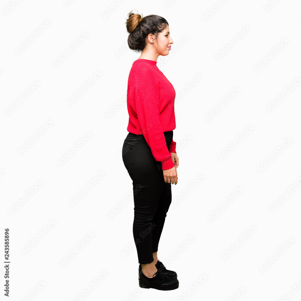 Young beautiful woman wearing red sweater and bun looking to side, relax profile pose with natural face with confident smile. Young beautiful woman wearing red sweater and bun looking to side, relax profile pose with natural face with confident smile.