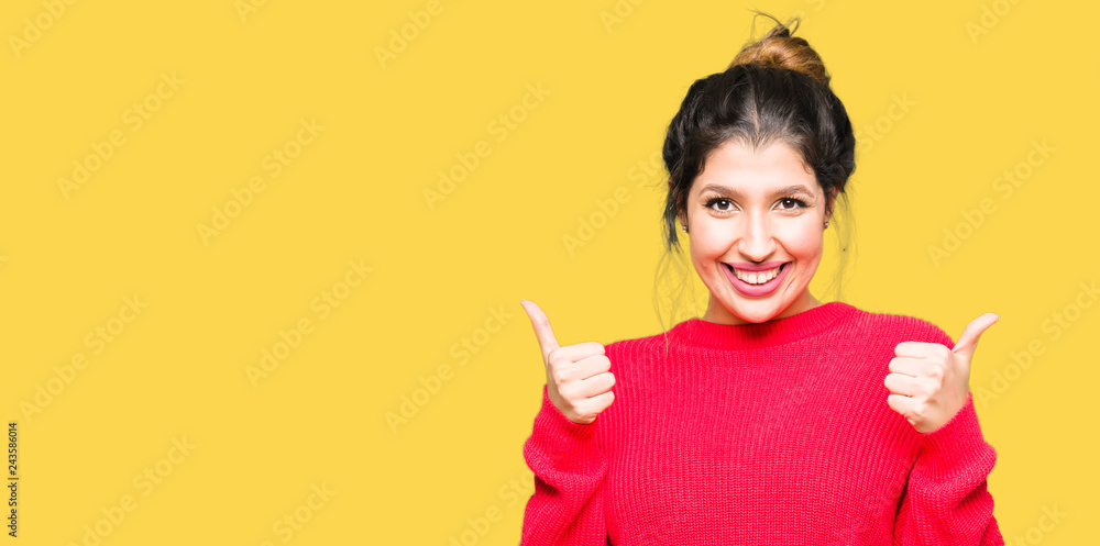 Young beautiful woman wearing red sweater and bun success sign doing positive gesture with hand, thumbs up smiling and happy. Looking at the camera with cheerful expression, winner gesture. Young beautiful woman wearing red sweater and bun success sign doing positive gesture with hand, thumbs up smiling and happy. Looking at the camera with cheerful expression, winner gesture.