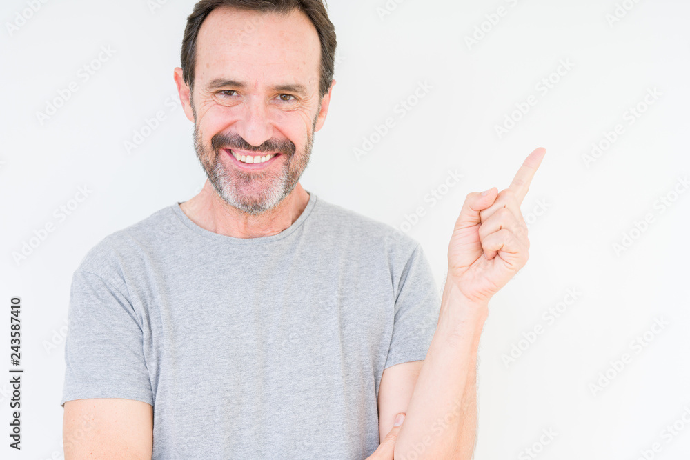 Handsome senior man over isolated background with a big smile on face, pointing with hand and finger to the side looking at the camera. Handsome senior man over isolated background with a big smile on face, pointing with hand and finger to the side looking at the camera.
