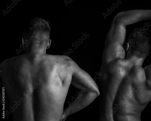 Two muscular guys posing in gym