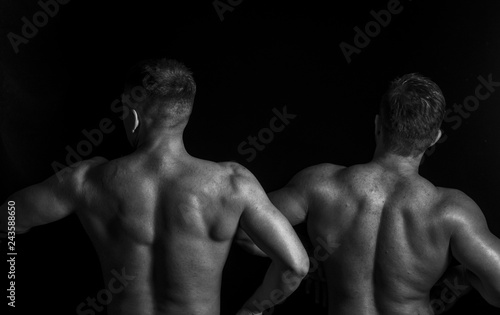 Two bodybuilders isolated on balck background