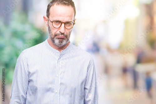 Middle age hoary senior man wearing glasses over isolated background depressed and worry for distress, crying angry and afraid. Sad expression.
