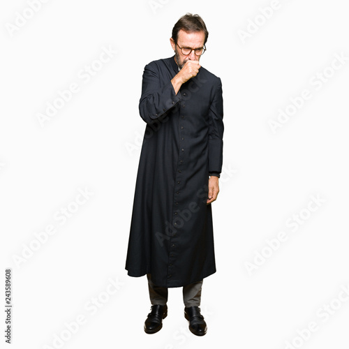 Middle age priest man wearing catholic robe feeling unwell and coughing as symptom for cold or bronchitis. Healthcare concept.