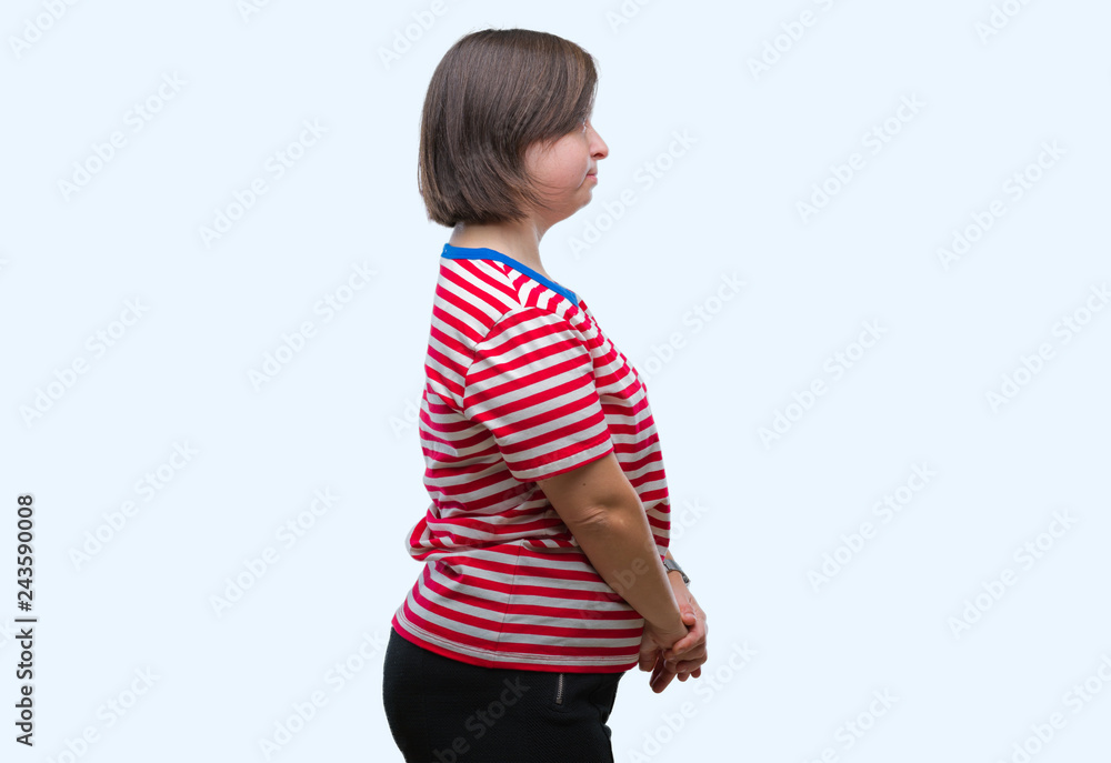 Young adult woman with down syndrome over isolated background looking to side, relax profile pose with natural face with confident smile. Young adult woman with down syndrome over isolated background looking to side, relax profile pose with natural face with confident smile.