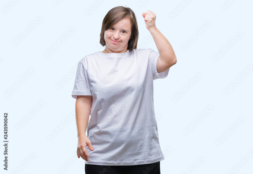 Young adult woman with down syndrome over isolated background angry and mad raising fist frustrated and furious while shouting with anger. Rage and aggressive concept. Young adult woman with down syndrome over isolated background angry and mad raising fist frustrated and furious while shouting with anger. Rage and aggressive concept.