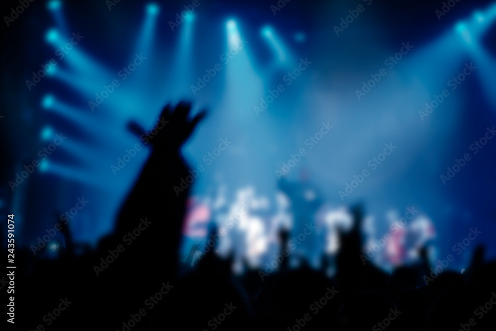 Musical concert. People in the concert hall at the disco . Singer in front of the audience. Fans at the concert. Blurred image / blurred photo.