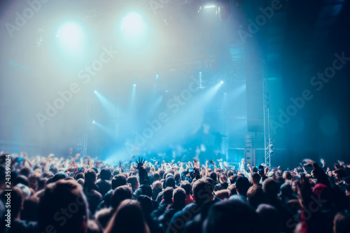Musical concert. People in the concert hall at the disco . Singer in front of the audience. Fans at the concert. Blurred image / blurred photo.