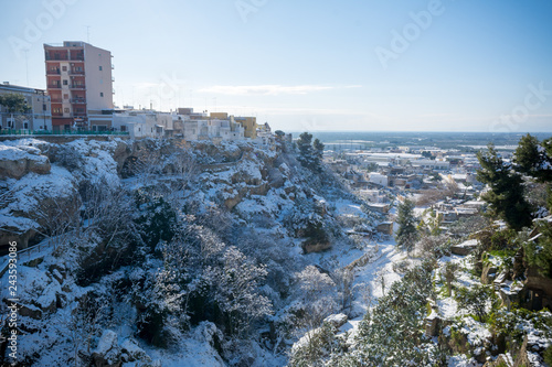 фотографія Horizontal View of the Gravina of the Town of Massafra, Covered by Snow on Blue