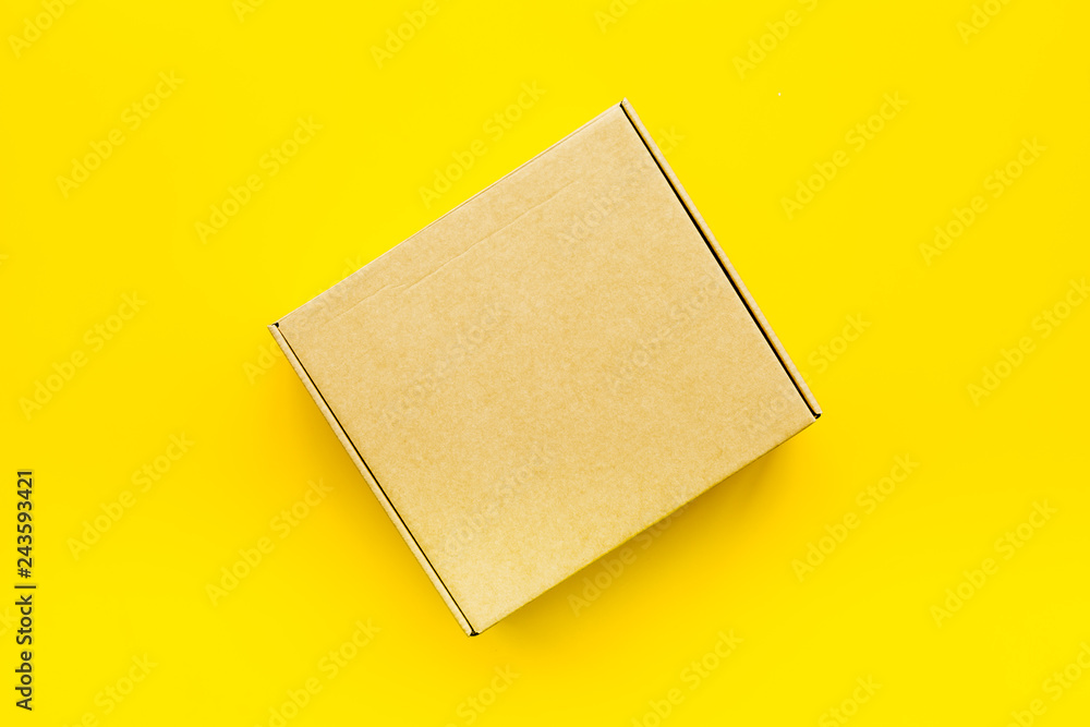 Delivery concept. Cardboard box on yellow background top view mockup Delivery concept. Cardboard box on yellow background top view mockup